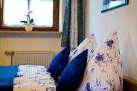 a bed with blue pillows on it with a window at Ferienwohnung AmmerZonas &amp; AmmerZone in Oberammergau