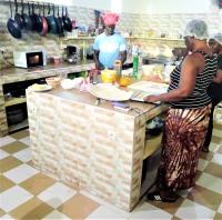 NiagaにあるLe Chamamaのキッチンで食事を準備している人々のグループ