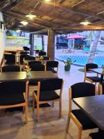 NiagaにあるLe Chamamaのテーブルと椅子とプールがあるレストラン