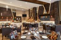 a restaurant with tables and chairs and a bar at Ramada by Wyndham Aligarh GT Road in Alīgarh