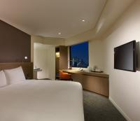 a hotel room with a bed and a flat screen tv at Royal Inn Taipei Linsen - Huashan 1914 Creative Park in Taipei