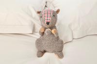 a stuffed animal is sitting on a bed at Napoléon Gare 5 STUDIO 1er Etage ByLocly in Pontivy