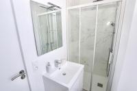 a white bathroom with a sink and a shower at Napoléon Gare 5 STUDIO 1er Etage ByLocly in Pontivy