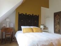 a bedroom with a large bed with yellow pillows at Chambres d&#39;Hôtes L’Échappée Belle in Saint-Brisson-sur-Loire
