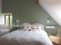 a bedroom with a white bed and a chair at Chambres d&#39;Hôtes L’Échappée Belle in Saint-Brisson-sur-Loire