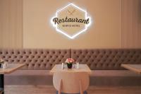 a restaurant with a bench and a table with flowers on it at Borys Hotel Boryspil Airport in Boryspilʼ