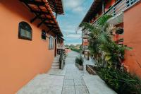 an alley between two orange buildings with a palm tree at Búzios Centro Hotel in Búzios