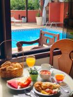 a table with breakfast food and a swimming pool at Búzios Centro Hotel in Búzios
