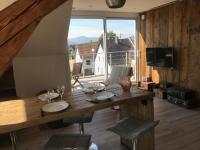 Un comedor con una mesa y un gran ventanal. en Appartement chaleureux et lumineux avec vue ! au centre Alsace, en Sélestat