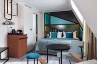 a hotel room with a bed and a table and chairs at Le 12 Hôtel in Paris