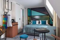 a bedroom with a bed and a table and a chair at Le 12 Hôtel in Paris