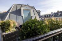 a glass house on a balcony with plants at Le 12 Hôtel in Paris