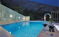 two glasses of wine sitting next to a swimming pool at Cozy Home In Makarska With Kitchen in Makarska