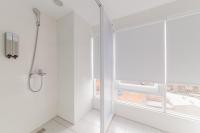 a white bathroom with a shower and a window at LIHO Hotel Tainan in Tainan