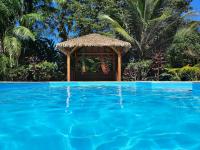a gazebo next to a blue swimming pool at Villa Kannel in Petit-Bourg