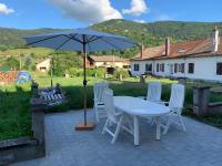 a table and chairs with an umbrella on a patio at Le Ruisseau à Bussang Htes Vosges tout confort in Bussang