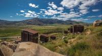 a group of buildings on a hill with mountains in the background at Encuentro Guadalupe in Valle de Guadalupe