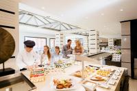 a group of people standing in a kitchen preparing food at Royal Hideaway Sancti Petri in Chiclana de la Frontera