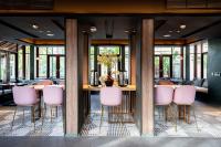 a dining room with a table with pink chairs at Grand Mercure Khao Lak Bangsak in Khao Lak