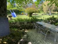 Una mesa con sillas y un cartel en un parque. en Au Sans Souci, en Saint-Paul-lès-Monestier