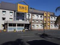 un edificio con una señal solar frente a un aparcamiento en SUN1 Durban, en Durban