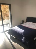 a bedroom with a bed and a large window at T3 moderne et spacieux à BASTIA in Bastia
