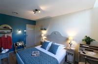 a bedroom with a bed with blue walls and a desk at The Originals Boutique, Hôtel du Parc, Cavaillon (Inter-Hotel) in Cavaillon