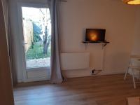 a room with a window and a door with a television at Un jardin en ville in Talence