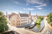a view of a city with a river and buildings at Hotel Augustyn Brugge in Bruges