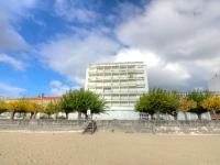 a building on the beach with trees in front of it at Apartment Les Autans by Interhome in Royan