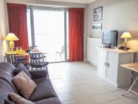a living room with a couch and a tv at Apartment Les Autans by Interhome in Royan