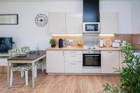 a kitchen with white cabinets and a table and a counter top at ONLOC - St Exupéry -Magnifique appart au calme avec chambre - parking in Pau