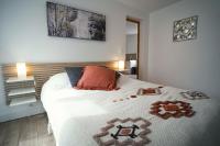 a bedroom with a large bed with a white blanket at ONLOC - St Exupéry -Magnifique appart au calme avec chambre - parking in Pau