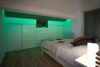 a bedroom with a bed and a green accent wall at ONLOC - St Exupéry -Magnifique appart au calme avec chambre - parking in Pau