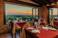 a restaurant with tables with wine glasses and a view at Villa Di Sotto in Castelnuovo Berardenga