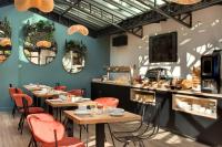 a restaurant with wooden tables and red chairs at Hôtel des Ducs in Dijon