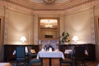 Un comedor con dos mesas y un espejo. en Hotel Schloss Neetzow, en Neetzow