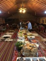 瓦迪拉姆Khaled's Camp - Wadi Rum的长长的自助餐台上摆满了食物，人们围着它站着。