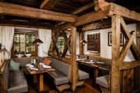een restaurant met houten wanden en tafels en stoelen bij Mountain Resort Patzenfeld in Sesto