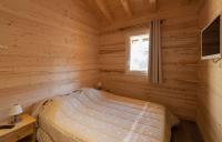 a bedroom with a bed in a log cabin at Odalys Chalet D&#39;Alice in Les Menuires