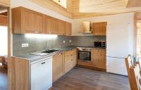 a kitchen with wooden cabinets and a white refrigerator at Odalys Chalet D&#39;Alice in Les Menuires