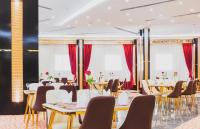 فندق السفينة الذهبية في الرياض: مطعم بالطاولات والكراسي والستائر الحمراء