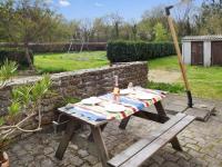 a picnic table in a garden with a bottle of wine at Maison d&#39;une chambre a Tredrez Locquemeau a 800 m de la plage avec jardin amenage et wifi in Coat-Tredrez
