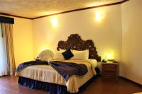 a bedroom with a large bed with a wooden headboard at Ecotel Quinta Regia in Valladolid