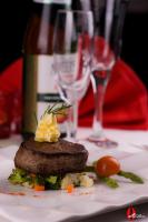 a plate with a piece of meat with a bottle of wine at The Convention Center & Royal Suites Hotel in Kuwait