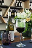 eine Flasche Wein neben einem Glas Wein in der Unterkunft The Originals Access, Hôtel Millau Sud in LʼHospitalet-du-Larzac