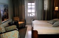 a bedroom with a bed and a chair and a window at Tertin Kartano in Mikkeli