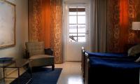 a room with a bed and a chair and a window at Tertin Kartano in Mikkeli