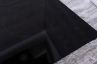 a close up of a black cutting board with a circle on it at Au nid douillet - Dormir Comme A La Maison in Châteaubriant