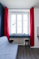 a bedroom with a bed and two windows with red curtains at Au nid douillet - Dormir Comme A La Maison in Châteaubriant
